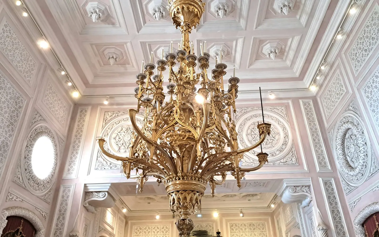 A gilded chandelier and stuccoed ceiling inside Pena Palace