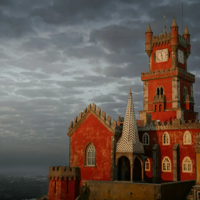 The red tower of Pena Palace under a dark evening sky