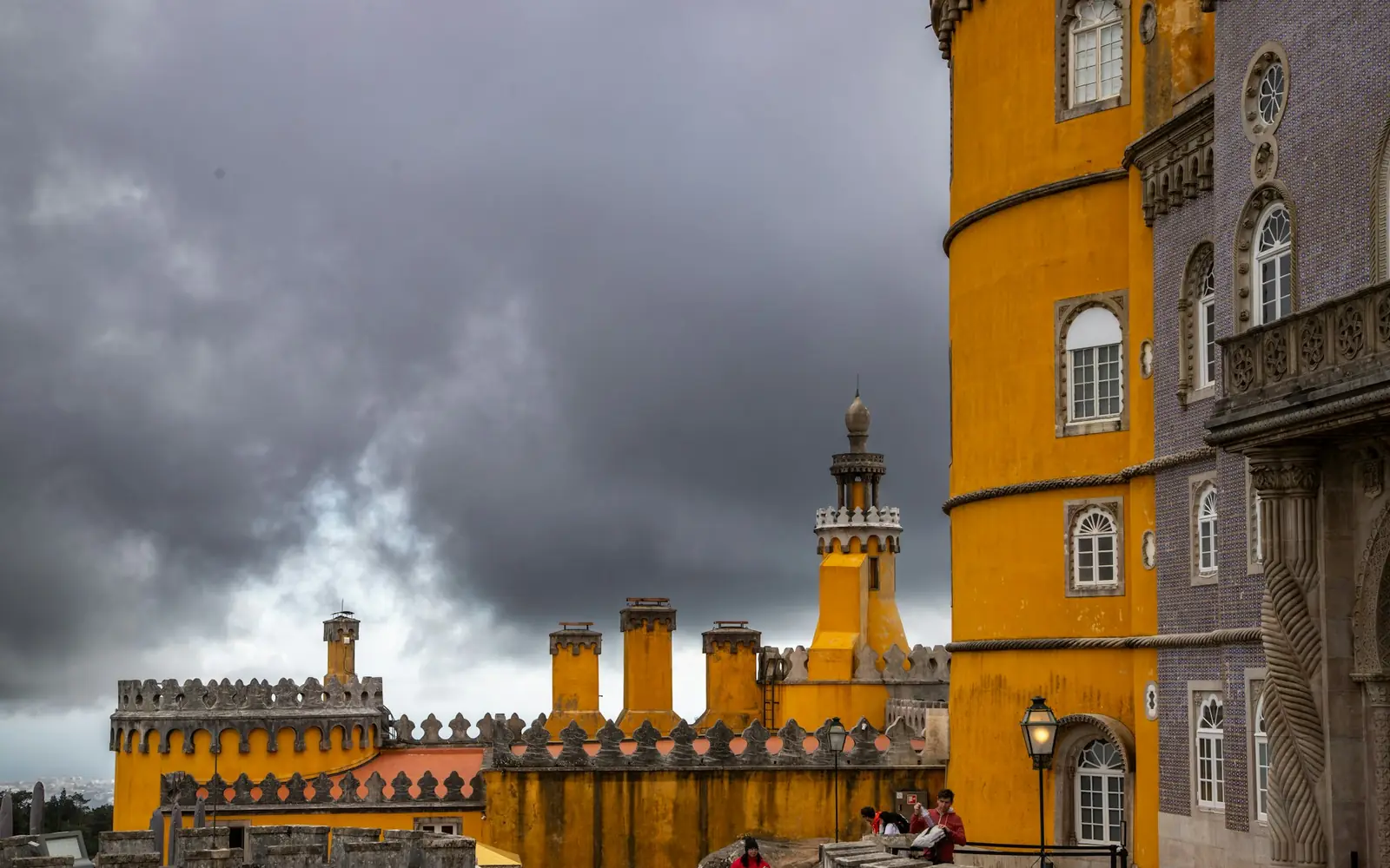 Storm clouds gathering over the yellow walls and towers of Pena Palace