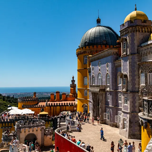 The domed terrace of Pena Palace with visitors looking out over the coast