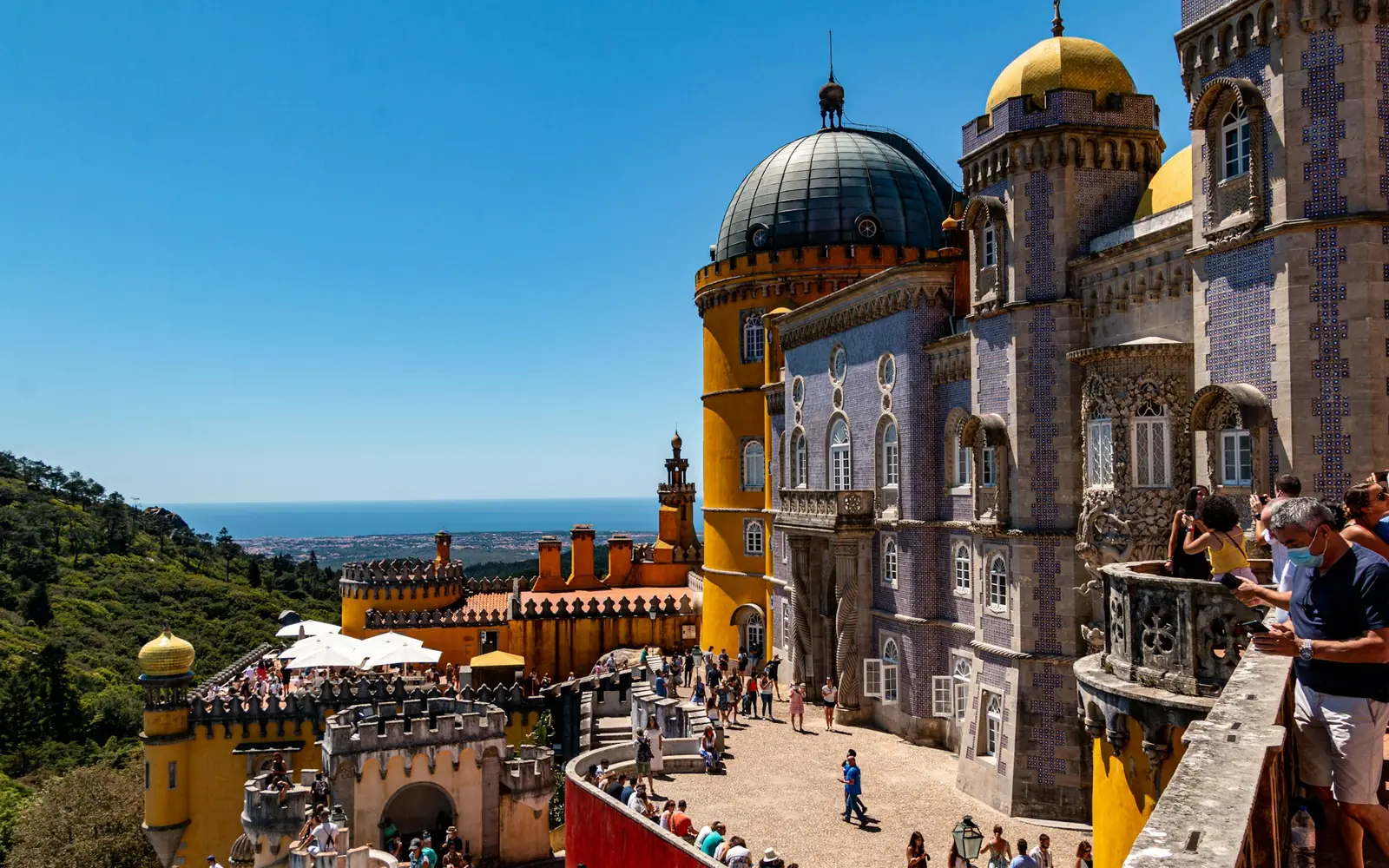 The domed terrace of Pena Palace with visitors looking out over the coast